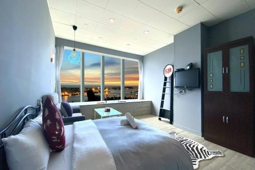 高雄85高雄港商旅的一间卧室设有一张大床和一个大窗户