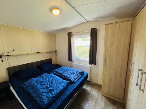 海牙Vakantiepark Kijkduin - 711的一间小卧室,内有蓝色的床