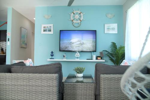 法哈多Kikis Beach House的客厅配有沙发和蓝色墙壁上的电视