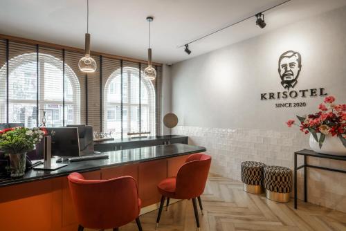 阿姆斯特丹Krisotel的餐厅设有配备橙色椅子的酒吧