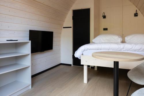 宁斯佩特Boslodges Veluwe的客房设有两张床、一张桌子和一台电视机。