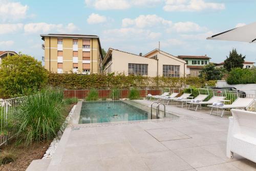 卢卡Villa Fedora Luxury Suites的一座带躺椅的游泳池位于大楼旁