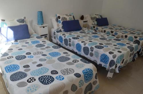 AlojeraVv Puesta de Sol的两张带蓝色和白色床罩的床