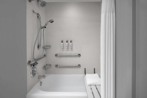 休斯顿休斯顿洲际机场春季山丘套房酒店的带淋浴和盥洗盆的白色浴室