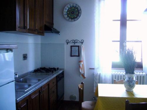 芬奇Agriturismo La Burra di Vinci Appartamento "Casina"的厨房配有水槽和带花瓶的桌子