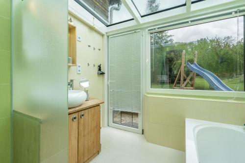 LangenwetzendorfChalet Kunterbunt的一间带水槽的浴室和一个带滑梯的窗户