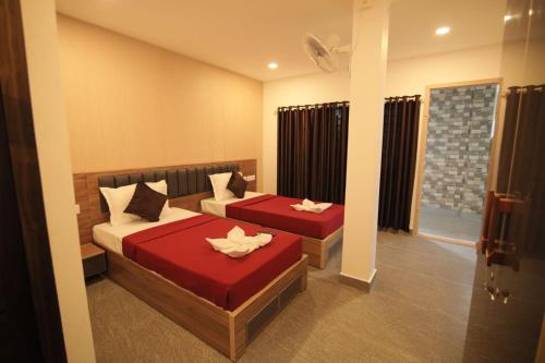 PayyannūrAfa Residency的一间卧室配有两张红色床单