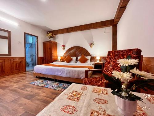 马拉里Ganga Cottage !! 1,2,3 bedrooms cottage available near mall road manali的配有一张床和一把椅子的酒店客房