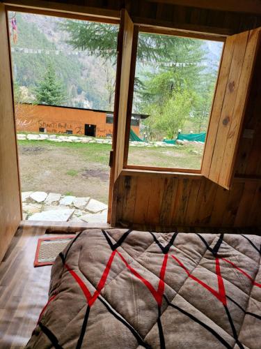 卡索尔Shanti People Huts & Camp的窗户客房内的一张床位