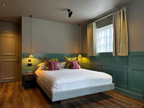 伊辛沃尔德The George Hotel Easingwold的一间卧室设有一张大床和一个窗户。