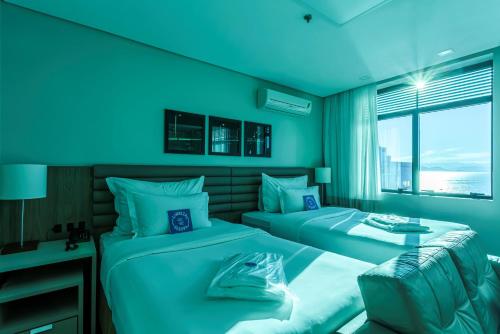 弗洛里亚诺波利斯蓝树高级弗洛里亚诺波利斯旅馆的蓝色的客房设有两张床和窗户。