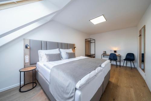 布拉格Hotel LEON的卧室配有一张白色大床和两把椅子