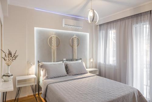 毕达哥利翁Pythagorio Blue Street Apartment with Balcony的卧室配有一张床铺,墙上挂有两面镜子