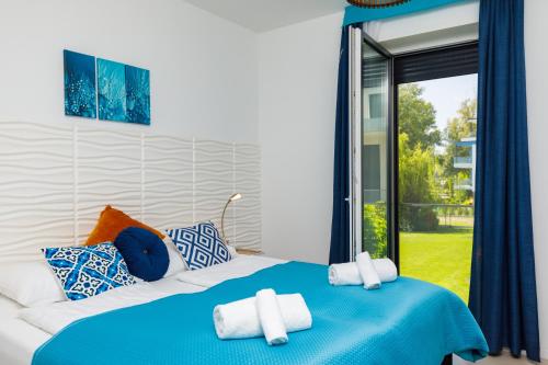 巴拉顿菲兹弗Blue4 Apartment的卧室配有蓝色和白色的床和窗户。
