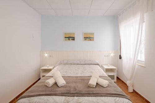 巴尔巴特Apartamento playa del Carmen的一间卧室配有一张大床和两张白色的桌子