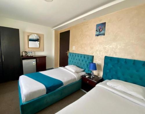开罗Royal Golden Pyramids Inn的酒店客房设有两张带蓝色床头板的床。