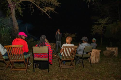 奈瓦沙Elsamere Lodge Naivasha的一群人晚上坐在草坪椅上