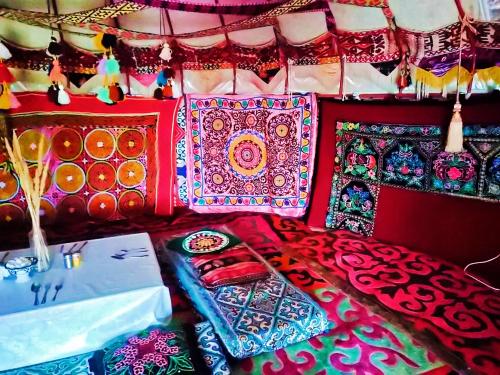 TürgenЮрта 6-канатная的床上配有色彩缤纷的毯子和枕头
