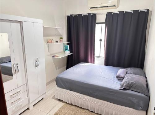 锡诺普Casa privada em Sinop的一间卧室配有一张床、一个梳妆台和一扇窗户。