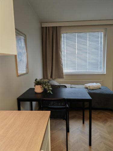 库萨莫New central home的客房设有桌子、床和窗户。