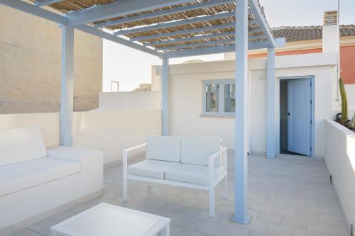 瓜尔达马尔·德尔·塞古拉Luxury Houses La Mar de Bonita的一个带白色椅子和凉亭的庭院