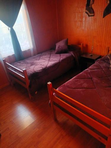 CabreroCabaña el ricky的一间卧室设有两张床和窗户。