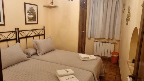 TodolellaA和B乡村鹦鹉公寓酒店的一间卧室配有两张带毛巾的床