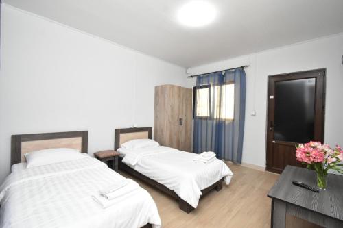 ArmavirSIRIK的配有白色墙壁和木地板的客房内的两张床