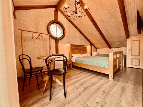 泰拉维VinoOdor - ვინოოდორ的卧室配有一张床和一张桌子及椅子