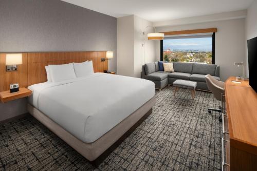 丹佛丹佛樱桃溪凯悦广场酒店的卧室配有一张白色的大床和一张沙发。