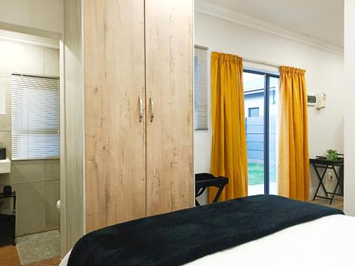哈里史密斯Olive Tree Studio Apartment的一间卧室设有大型木制橱柜和一张床