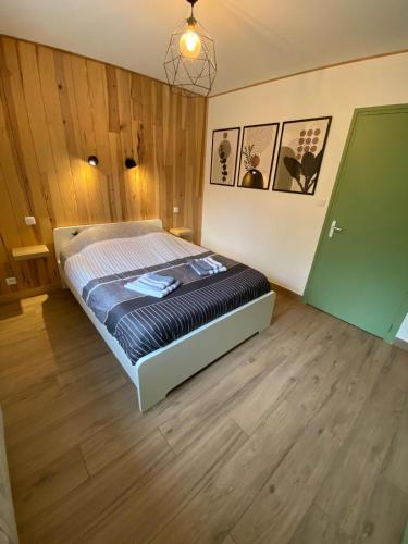 维拉尔-德朗Petit cocon comme a la maison的卧室配有一张床铺,位于带木墙的房间内
