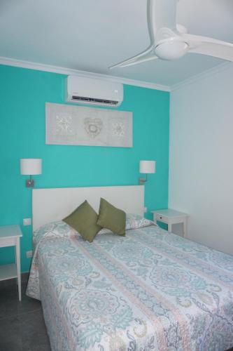 马斯帕洛马斯Bungalow Luisy的一间卧室配有一张蓝色墙壁的床