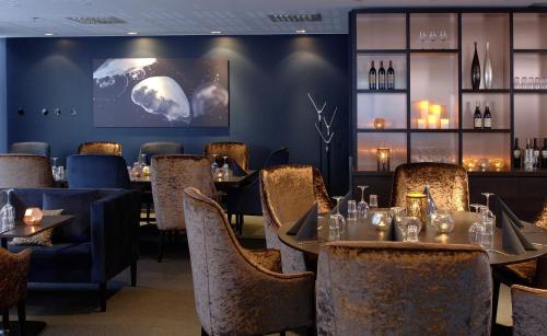 斯特伦斯塔德Strömstad Spa & Resort的一间带桌椅和屏幕的用餐室