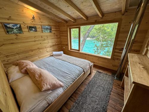 Llanada GrandePuelo Libre的小木屋的卧室,配有一张床和一个窗户