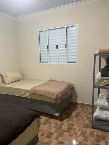 瓜鲁柳斯Casa do Monte的一间卧室设有两张床和窗户。