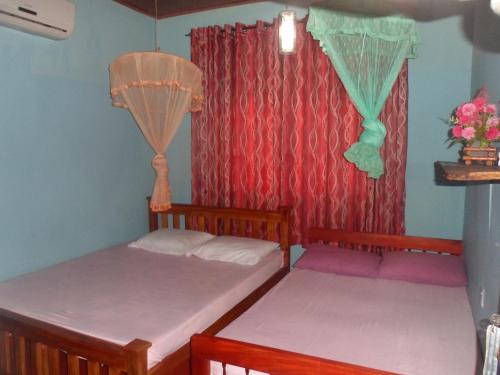 波隆纳鲁沃提萨尔旅馆的带窗户的客房内设有两张单人床。