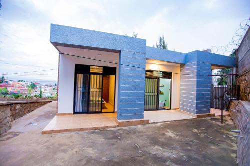 基加利Guest Suite in Kigali的蓝色和白色的房子,有车道