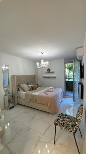 蒙彼利埃Appartement luxury的一间卧室配有一张床、一把椅子和一个吊灯。
