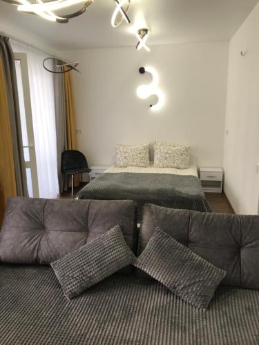 切尔尼戈夫Light Apartments的客厅配有床和沙发及枕头