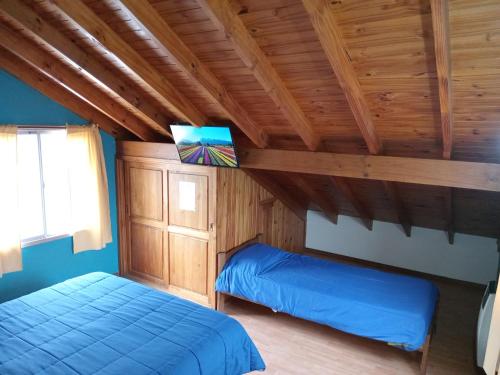 胡宁德洛斯安第斯Hostel El Reencuentro的一间带两张床的卧室,位于木天花板的房间