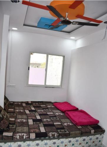 乌贾因Hotel Parvati Stey Home Ujjain的配有吊扇的客房内的一张床位