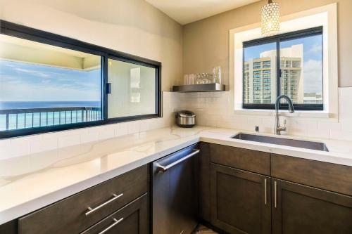 檀香山Aston Waikiki Beach Tower的一个带水槽和大窗户的厨房