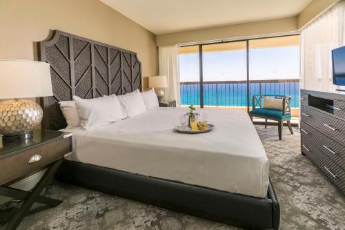 檀香山Aston Waikiki Beach Tower的一间卧室设有一张大床,享有海景