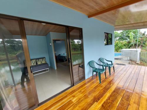 福尔图纳Arenal Surá的一间铺有木地板并配有玻璃门和椅子的客房