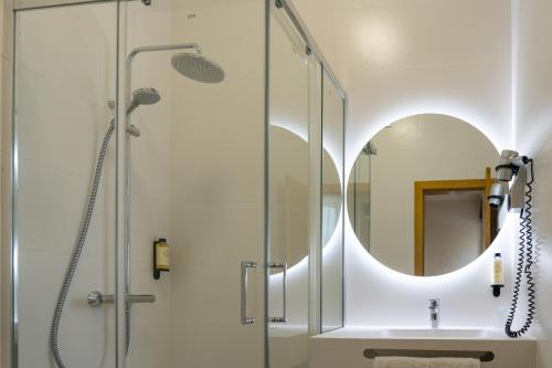 科英布拉维多利亚酒店 的带淋浴和盥洗盆及镜子的浴室