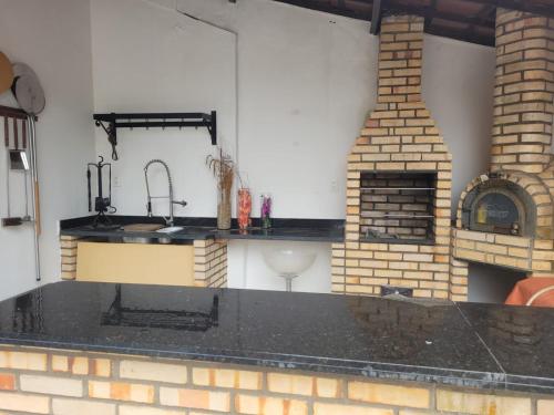 大坎皮纳Casa para temporada - São João 2024的厨房配有水槽和砖砌壁炉