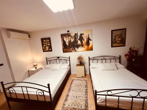 ŠirokaIart Residence的墙上有两张照片的房间,配有两张单人床