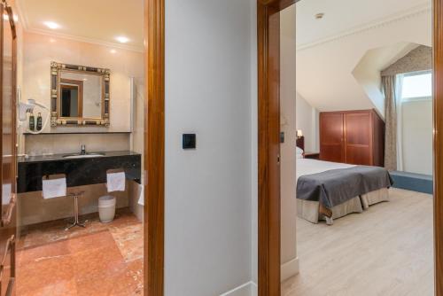莫格罗米拉格罗斯高尔夫Spa酒店的一间卧室配有一张床,浴室设有水槽