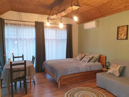奥格雷Pūču māja/Owl house namiņš Ogrē的一间卧室配有一张床、一张桌子和一张沙发